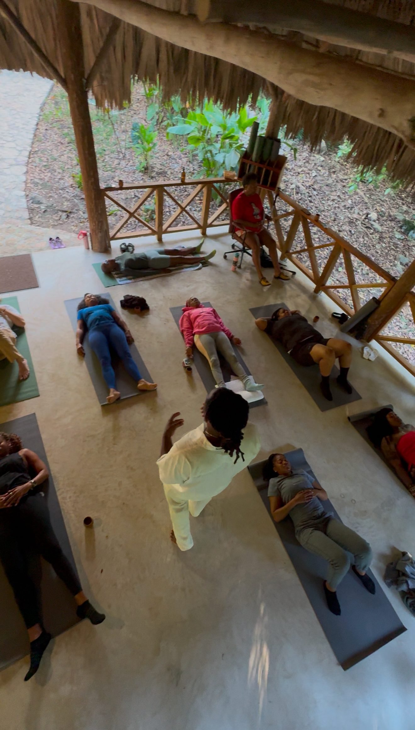 Group meditation ceremony under thatched roof